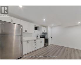 A kitchen with white cabinets and a stainless steel refrigerator.