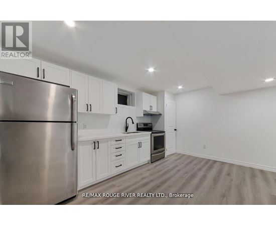 A kitchen with white cabinets and a stainless steel refrigerator.