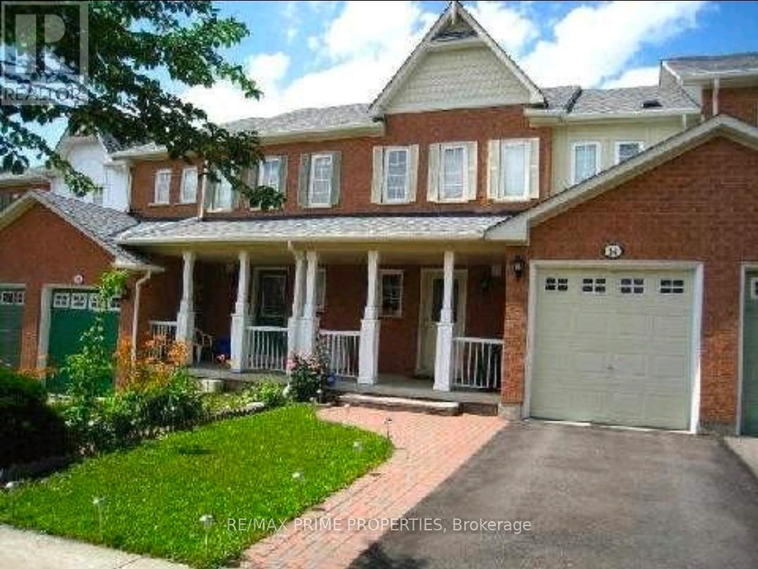 A brick house with a green door and a white garage door.
