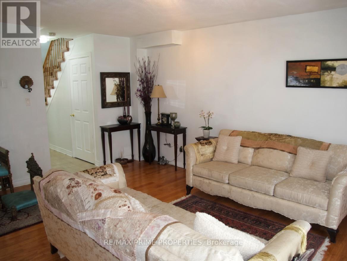 A living room with a couch, chair, and television.