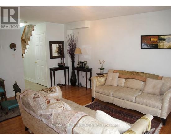 A living room with a couch, chair, and television.