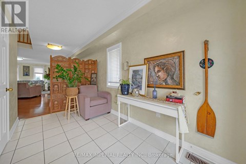 A living room with a white table and a painting on the wall.