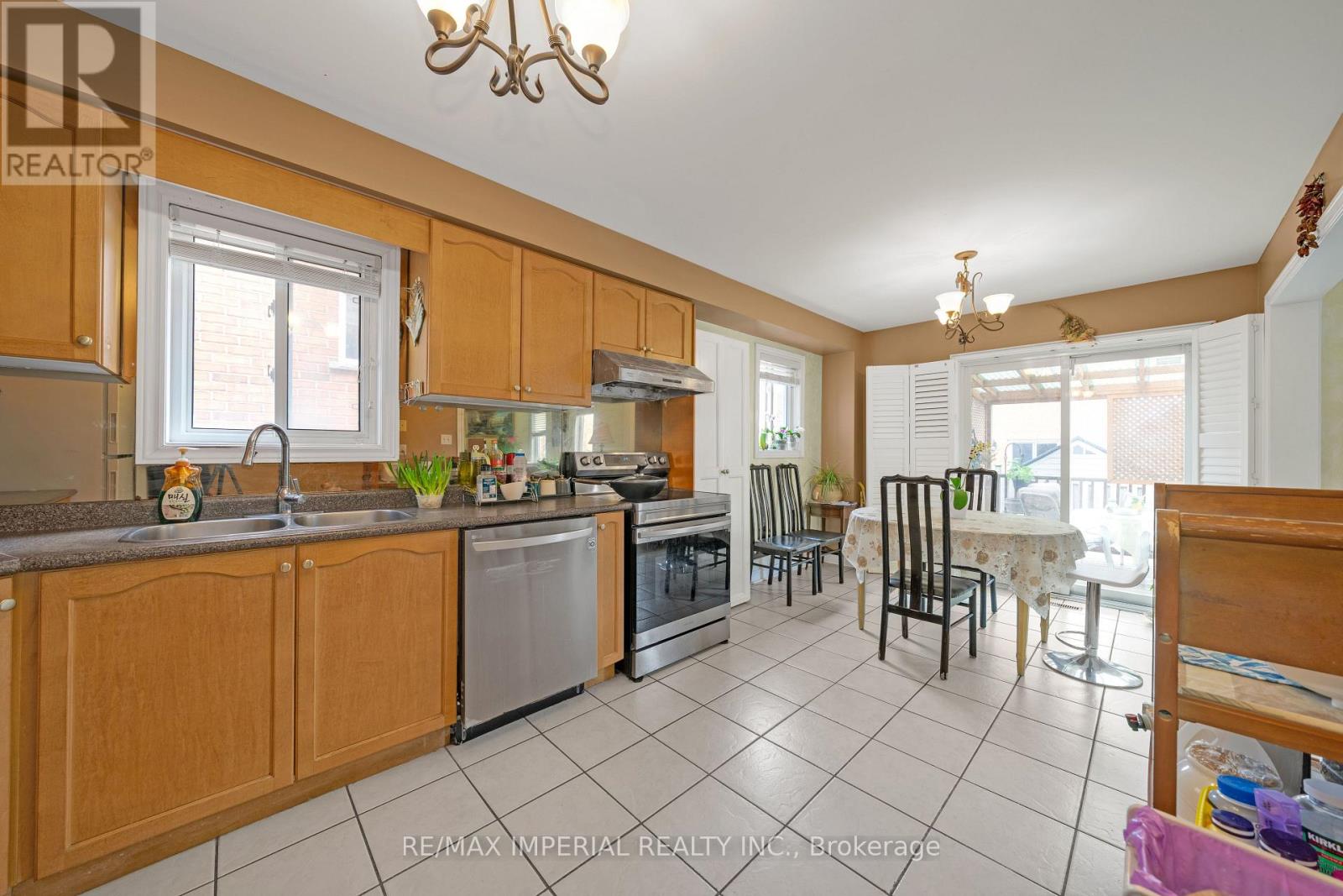 A kitchen with wooden cabinets and a tile floor.