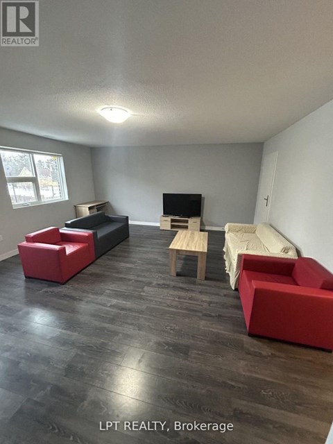 A living room with a red couch and a wooden table.