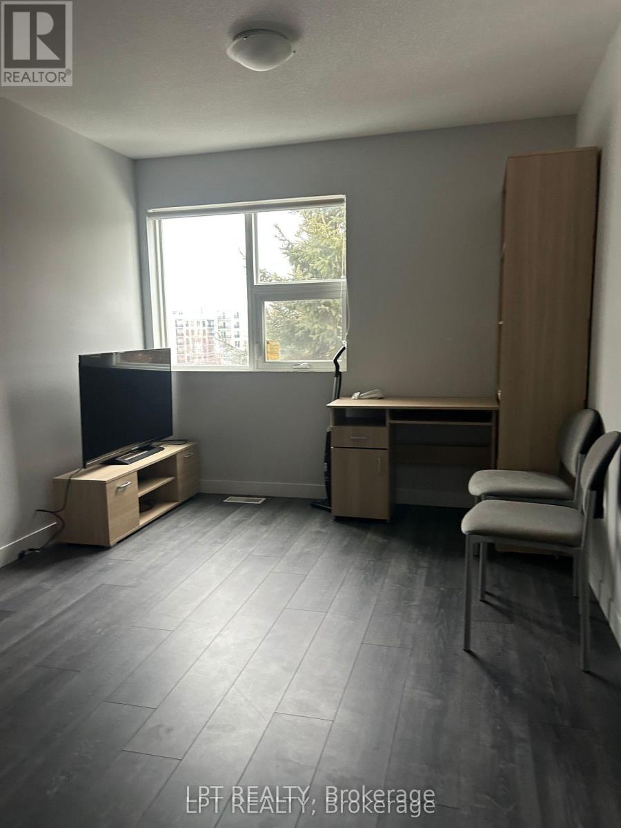 A living room with a grey floor and a large window.