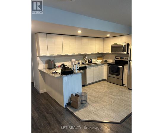 A kitchen with a white counter top and a black bag on it.