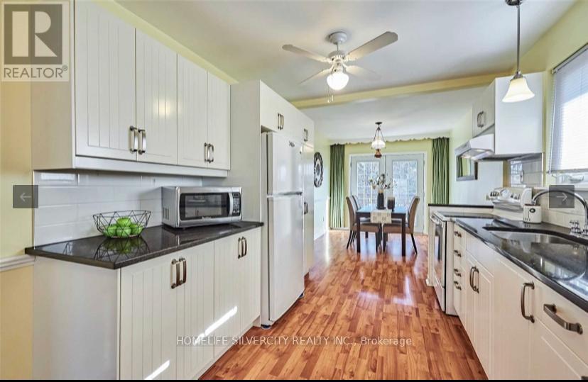 A kitchen with white cabinets and a black countertop.