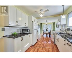 A kitchen with white cabinets and a black countertop.
