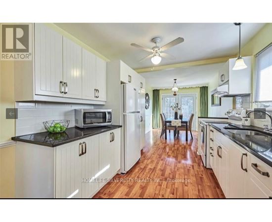 A kitchen with white cabinets and a black countertop.
