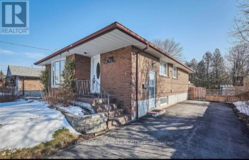 A brick house with a snow-covered ground in front.