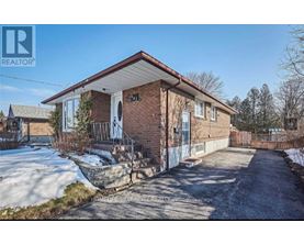 A brick house with a snow-covered ground in front.