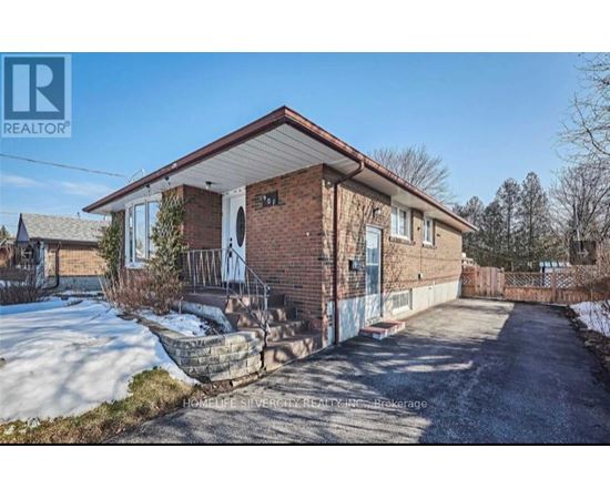 A brick house with a snow-covered ground in front.