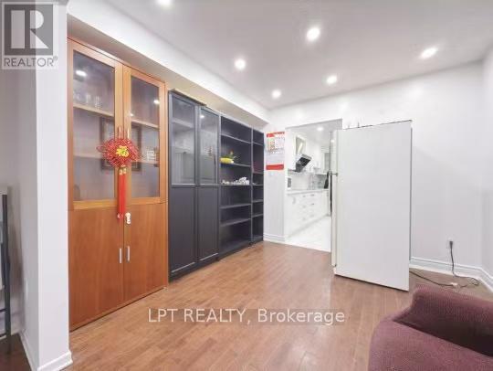 A room with wooden floors and a red door with a glass window.