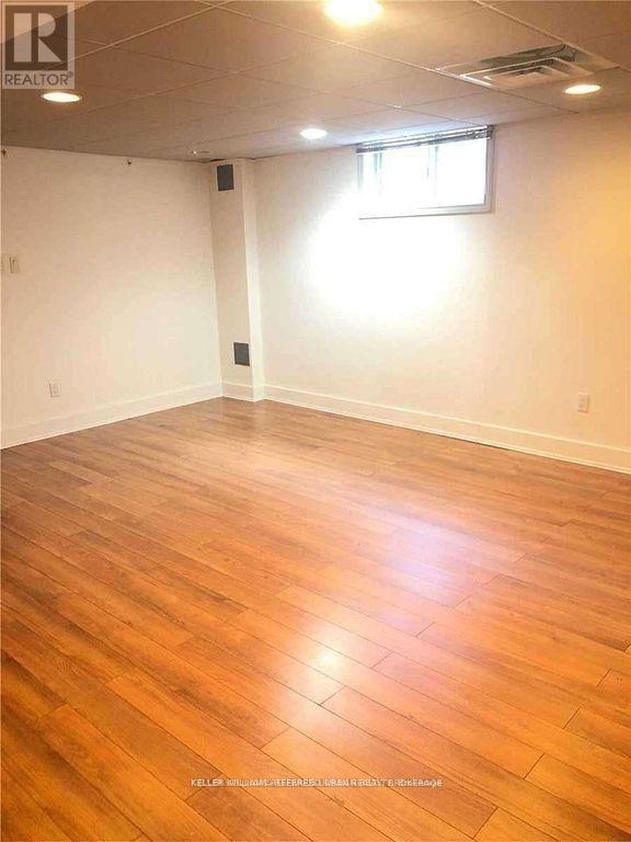 A room with wooden flooring and a window.