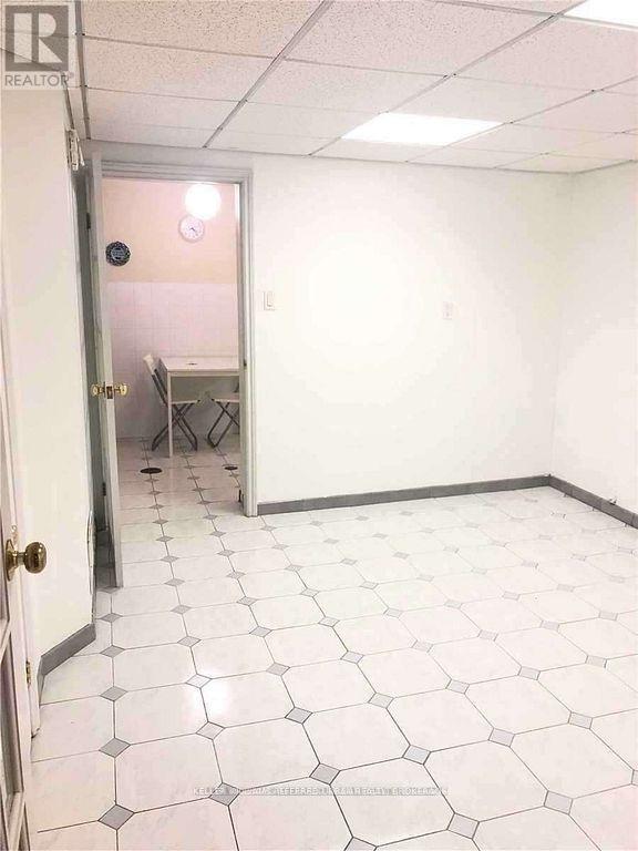 A room with white tile flooring and a door.