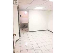A room with white tile flooring and a door.
