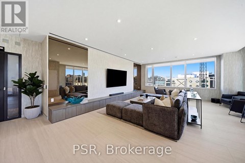 A modern living room with a large couch and a flat screen TV.