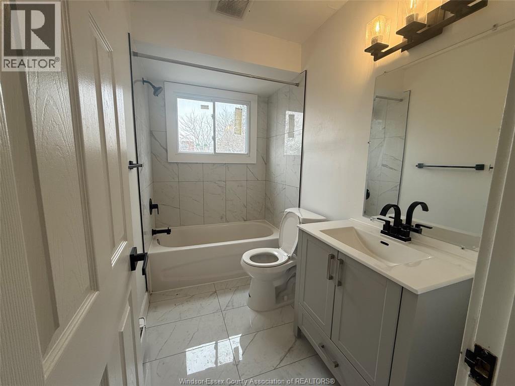 A bathroom with a toilet, sink, and shower.
