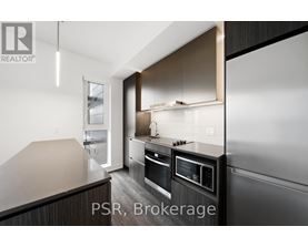 A modern kitchen with dark wood cabinets and stainless steel appliances.