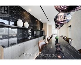 A modern dining room with a long table and chairs.
