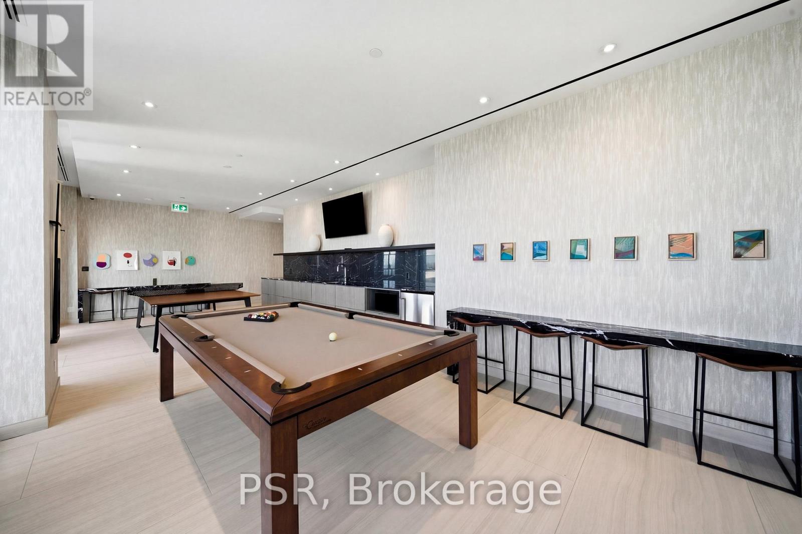 A pool table in a room with a bar area.