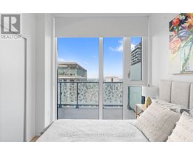 A bedroom with a large bed and a view of the city through the window.