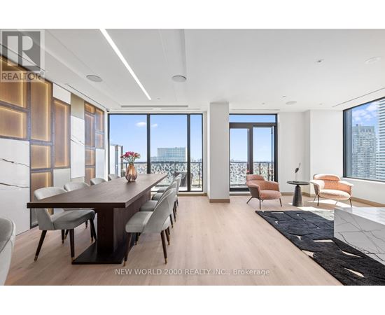 A modern dining room with a long table and chairs.