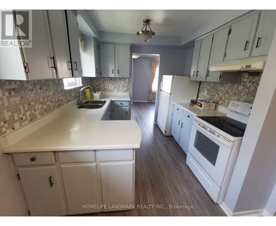 A kitchen with white cabinets and a tiled backsplash.