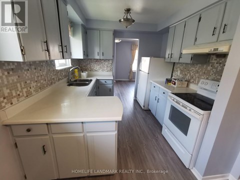 A kitchen with white cabinets and a tiled backsplash.