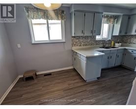 A kitchen with wooden floors and white cabinets.