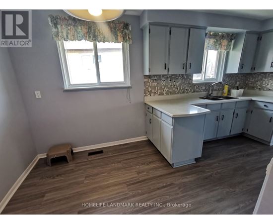 A kitchen with wooden floors and white cabinets.
