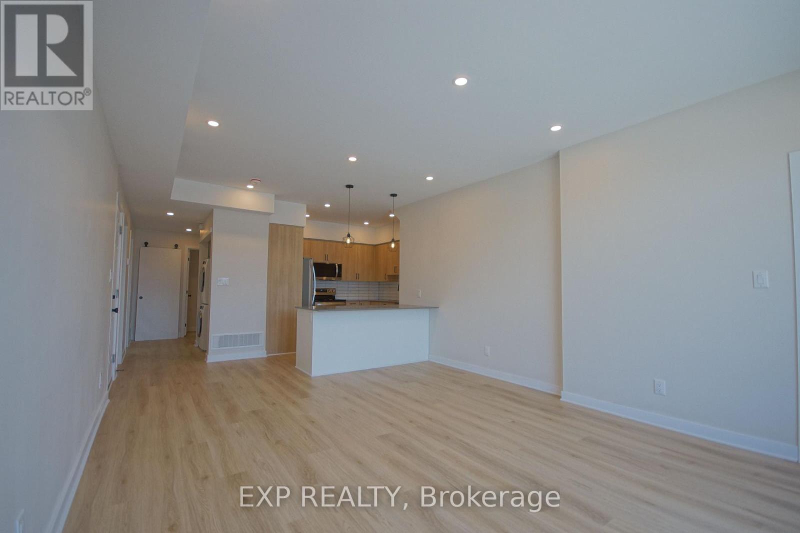 A large empty room with wooden floors and white walls.