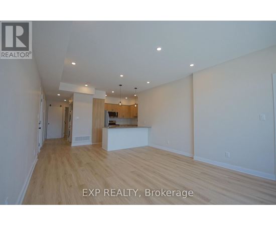 A large empty room with wooden floors and white walls.