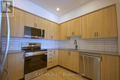 A kitchen with wooden cabinets and a stainless steel oven.