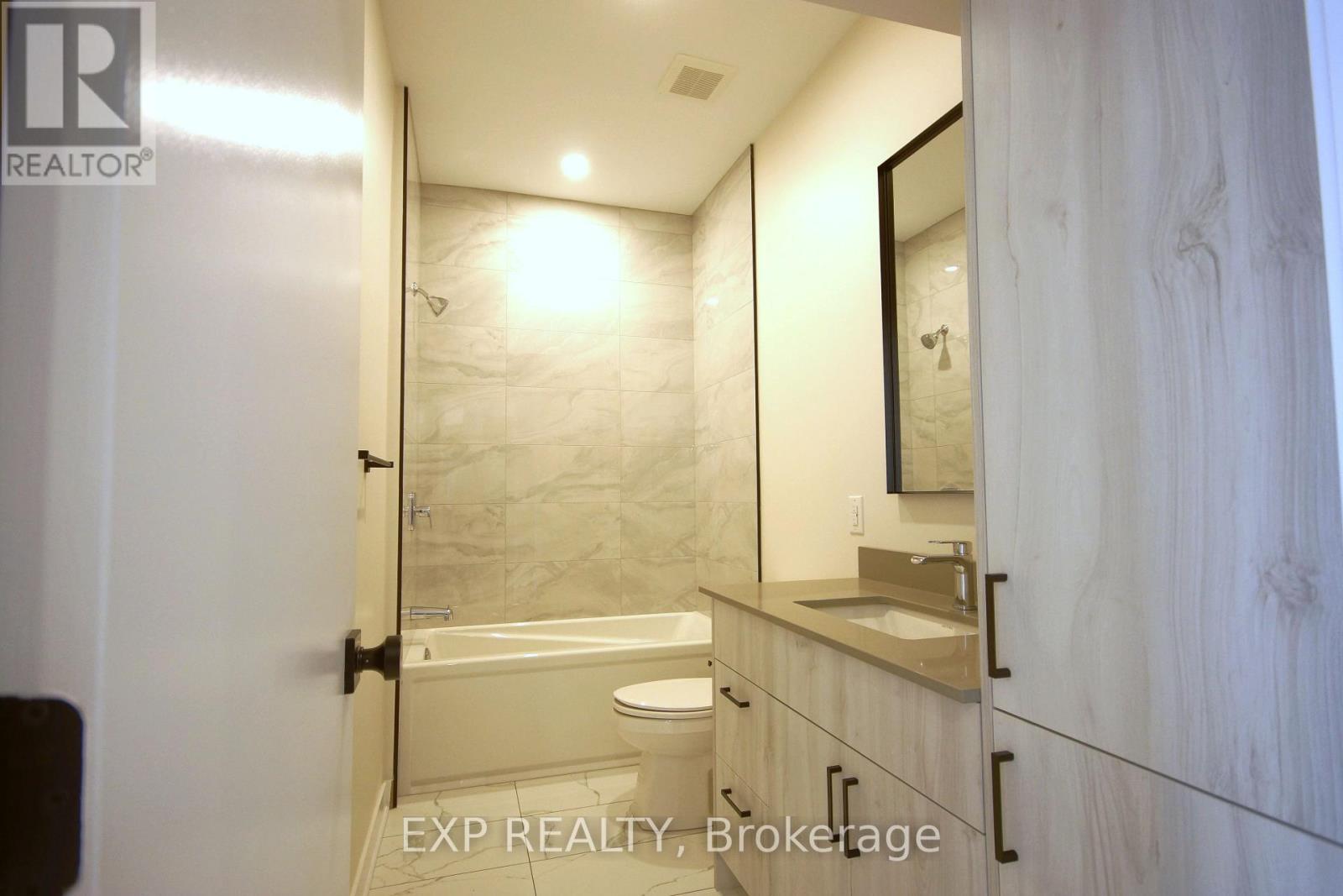 A bathroom with a toilet, sink, and mirror.