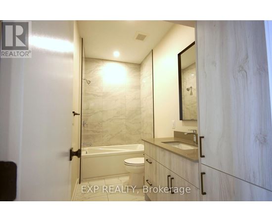 A bathroom with a toilet, sink, and mirror.