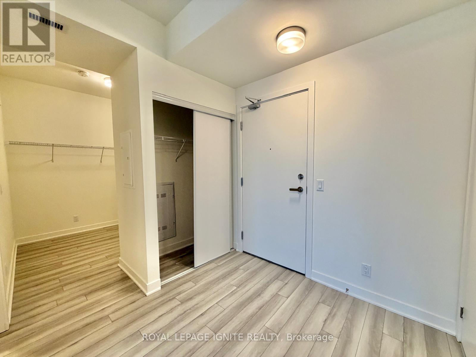 A white bedroom with a closet and a door.