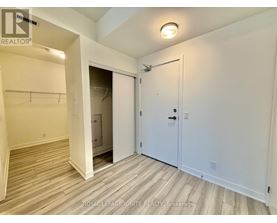 A white bedroom with a closet and a door.
