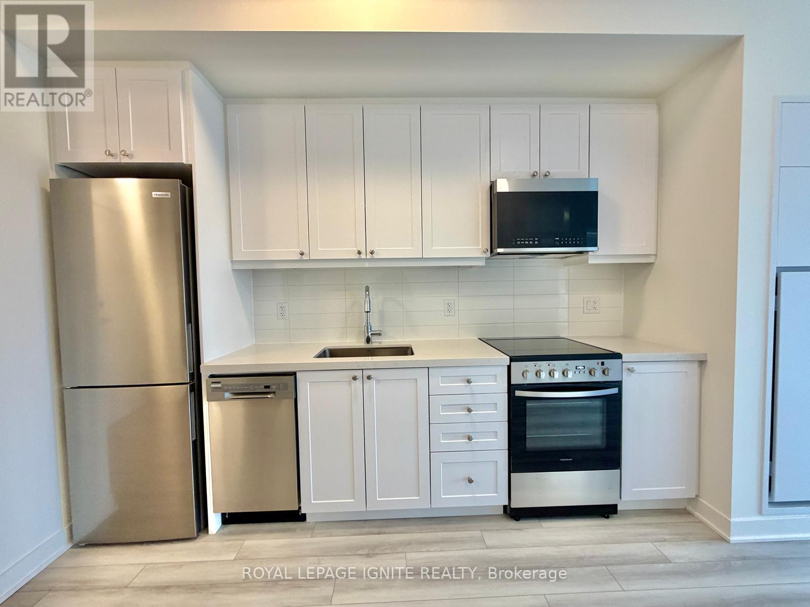 A kitchen with white cabinets and appliances.
