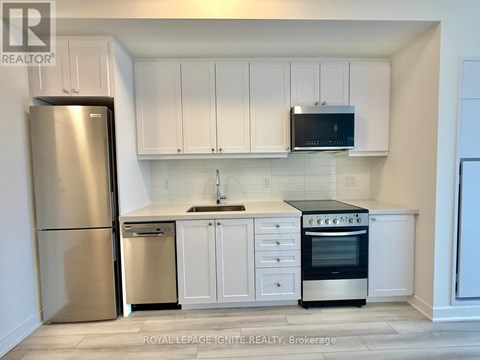 A kitchen with white cabinets and appliances.