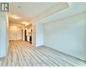 A spacious room with wooden flooring and white walls.