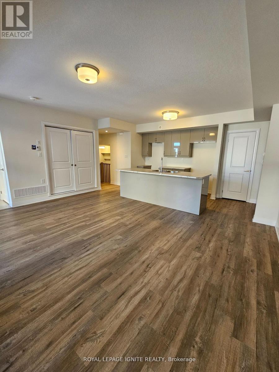 A spacious room with wooden flooring and white walls.