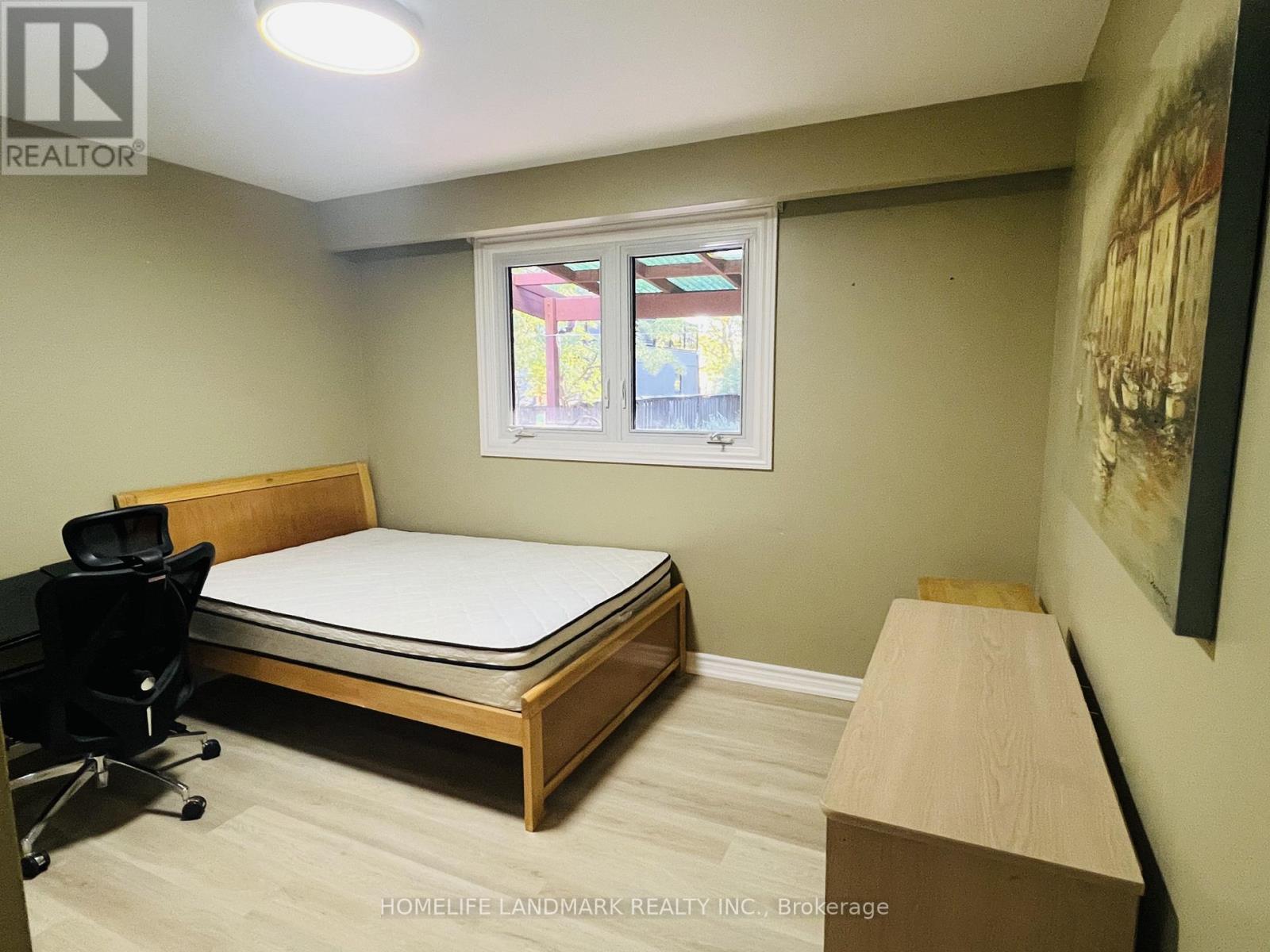 A bedroom with a bed, desk, and chair.