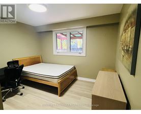 A bedroom with a bed, desk, and chair.