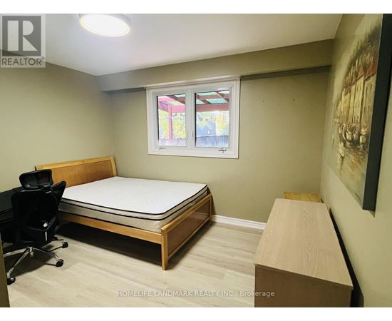 A bedroom with a bed, desk, and chair.