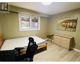 A bedroom with a bed, chair, and a painting on the wall.