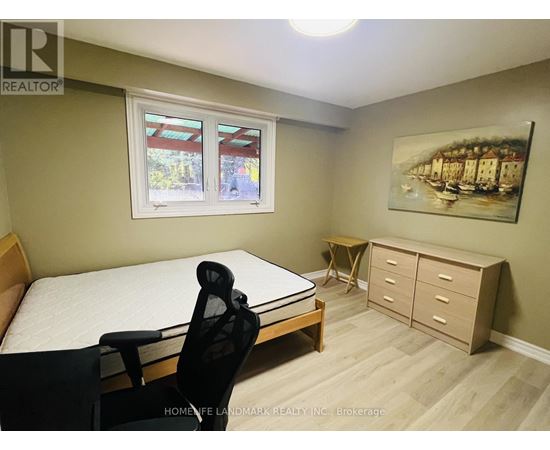 A bedroom with a bed, chair, and a painting on the wall.