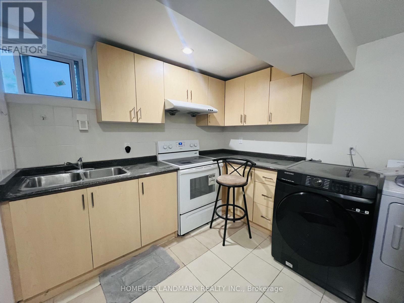 A kitchen with black countertops and wooden cabinets.