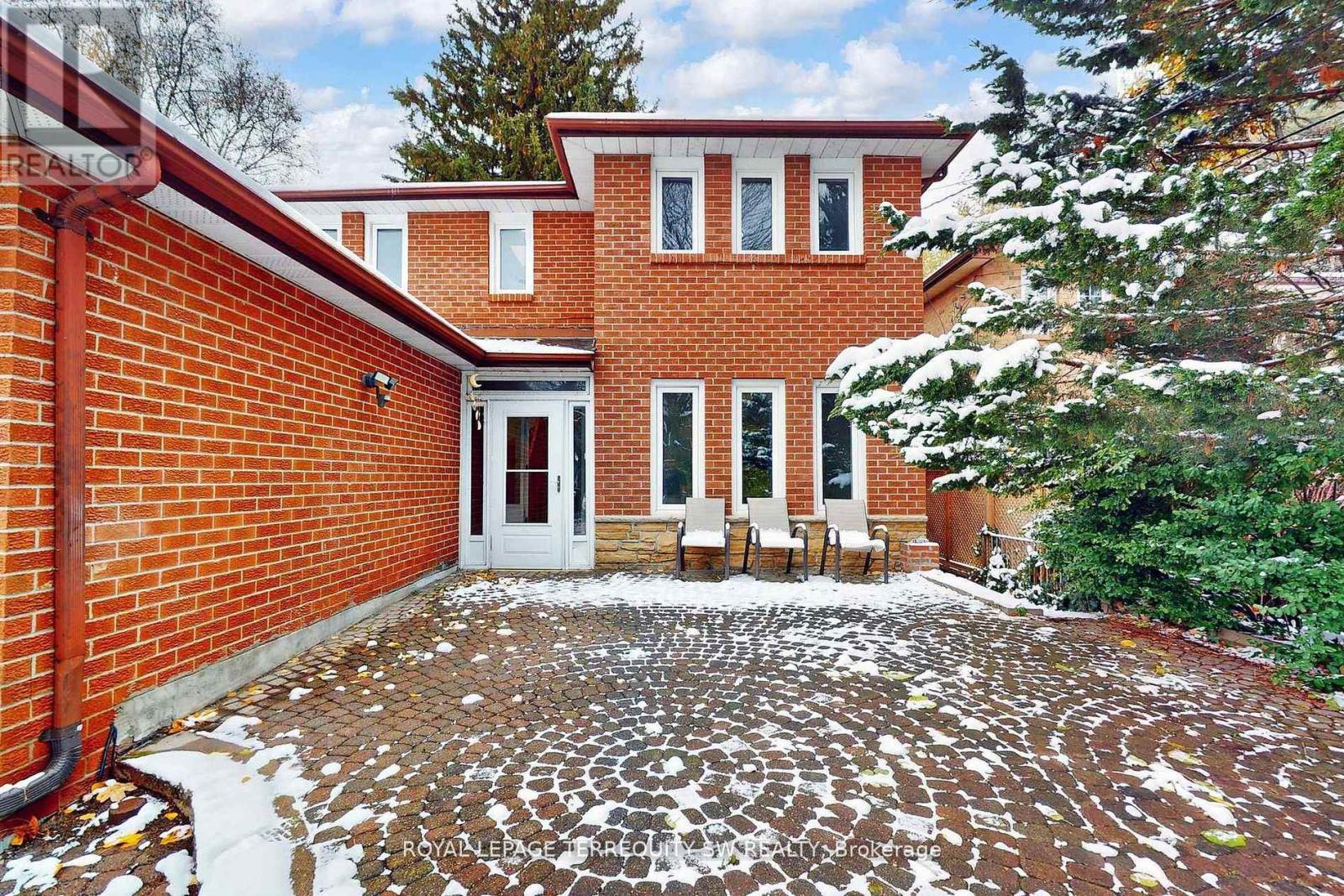 A red brick house with a white door and windows.