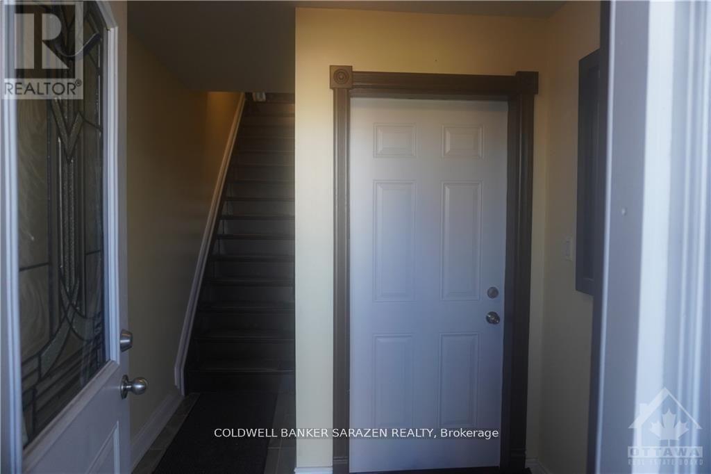 A white door is in a hallway with a staircase.
